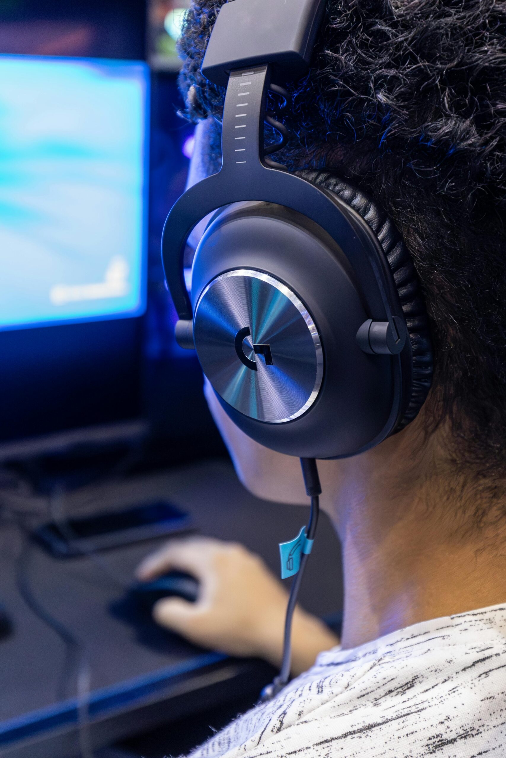 Close-up of a gamer wearing a headset, engrossed in gameplay, highlighting modern gaming technology.