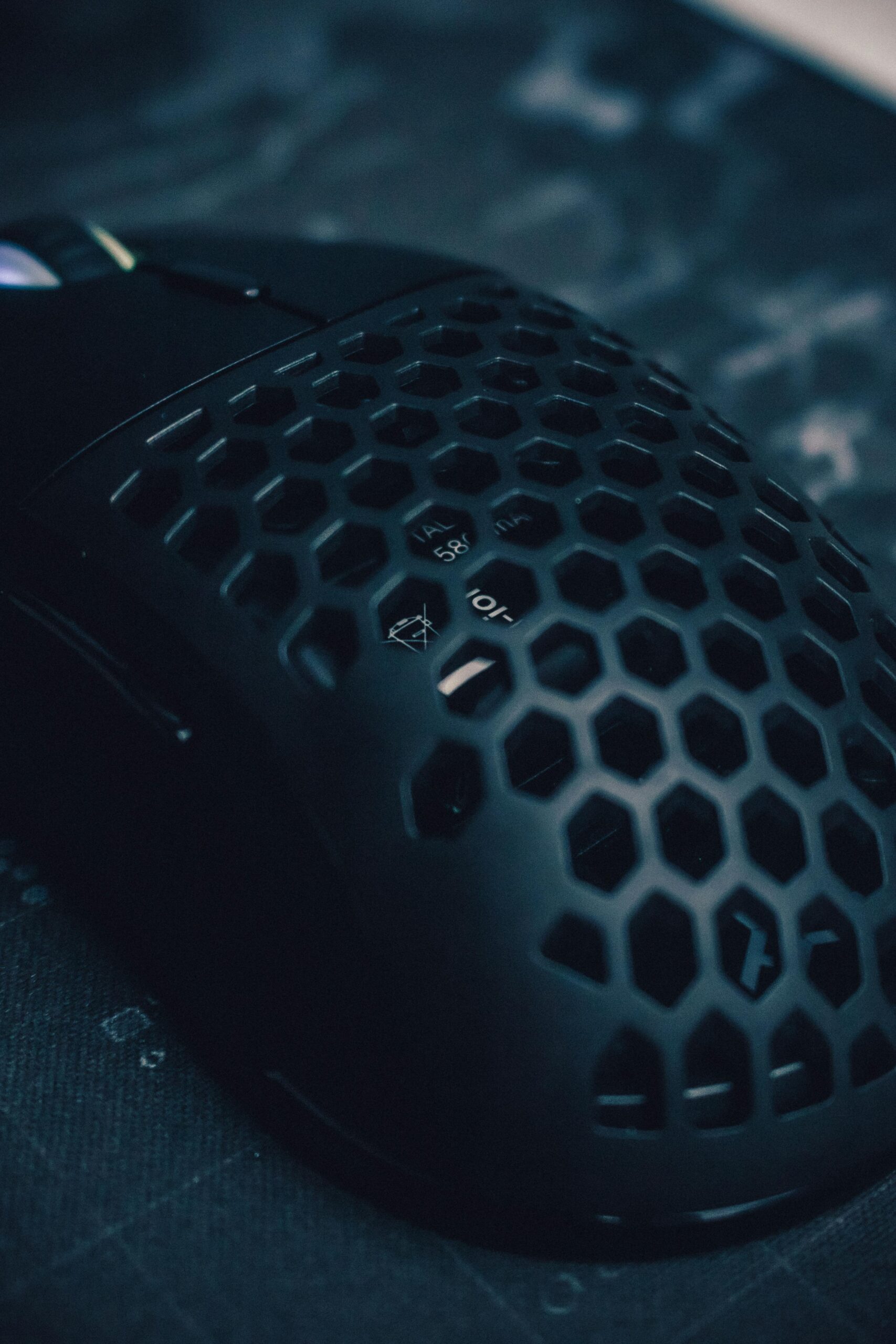 Close-up of a sleek black gaming mouse featuring a unique honeycomb pattern for ventilation and style.